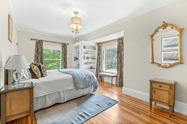 a bedroom with a bed a dresser and wooden floor