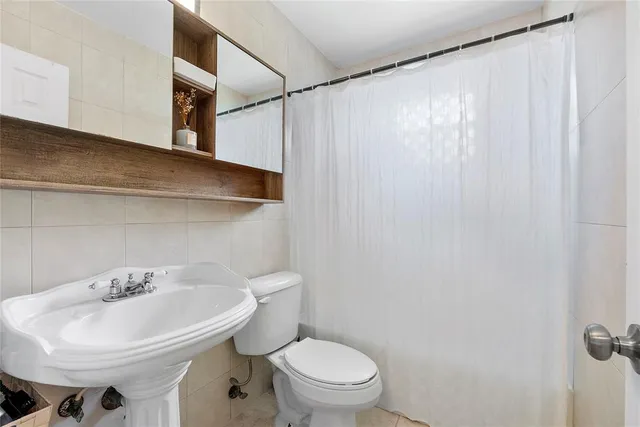 a bathroom with a sink a toilet and shower curtain