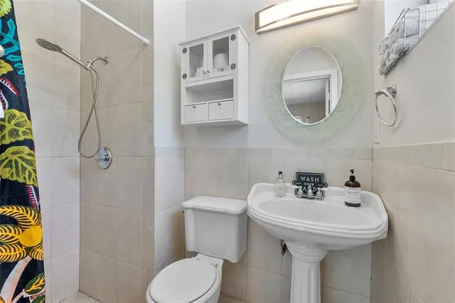 a bathroom with a sink a toilet and a mirror