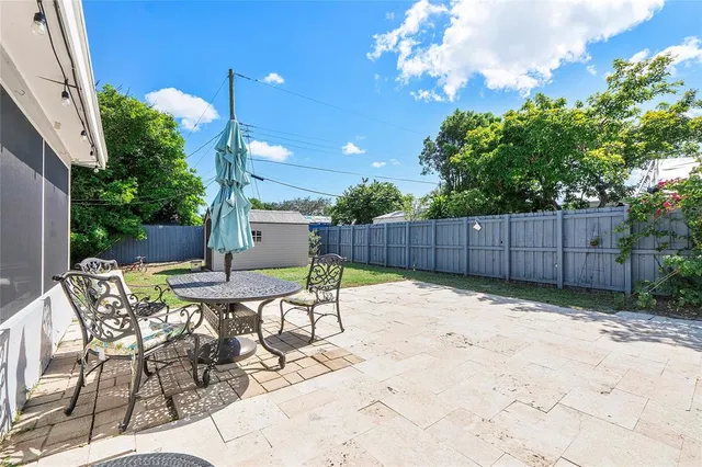a view of backyard with table and chairs and wooden fence