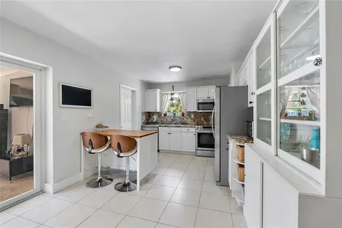 a kitchen with white cabinets and appliances