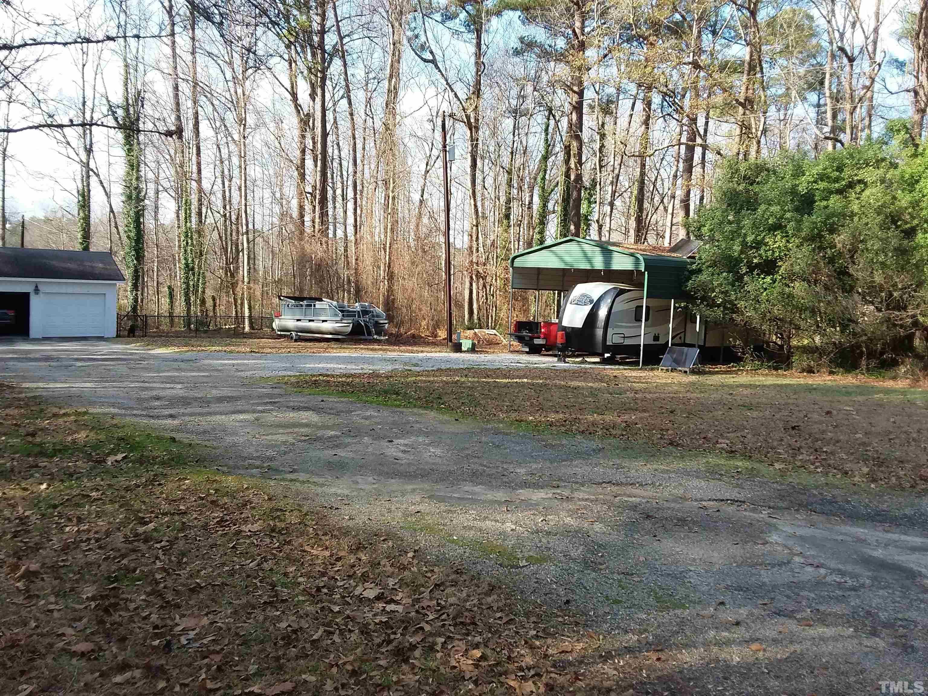 5029 Hurmax Lane Raleigh, NC 27610 - Photo 2 of 52 spacious front yard for your things. Carport remains with solar panels on top.