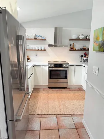 a kitchen with stainless steel appliances a stove a refrigerator and a cabinets