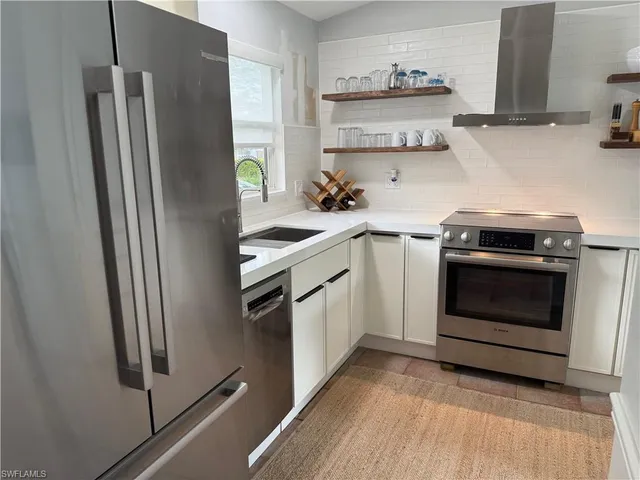 a kitchen with stainless steel appliances a stove a refrigerator and a sink