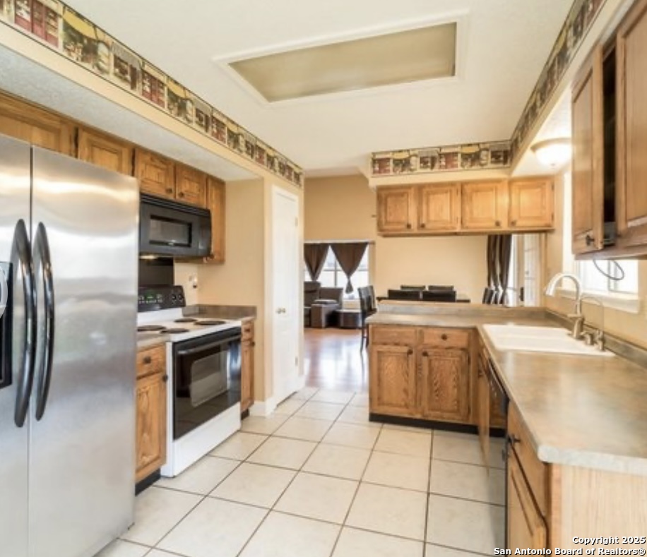 15022 Baycliff San Antonio, TX 78233 - Photo 5 of 15 a kitchen with granite countertop a sink stainless steel appliances and cabinets