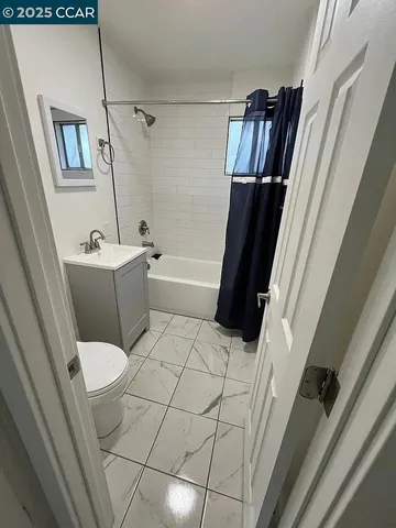 a bathroom with a sink a toilet a tub and shower