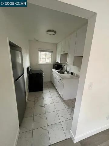 a kitchen with a sink a stove a refrigerator and cabinets
