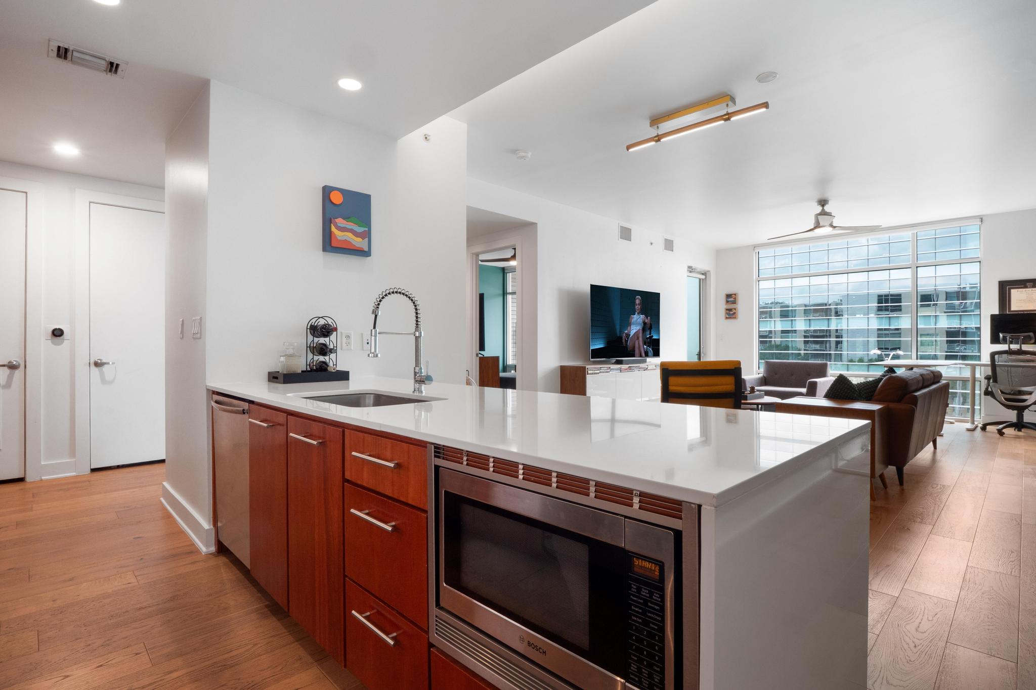 210 Lee Barton Drive, Unit 415 Austin, TX 78704 - Photo 21 of 22 Kitchen featuring visible vents, appliances with stainless steel finishes, modern cabinets, a sink, and open floor plan