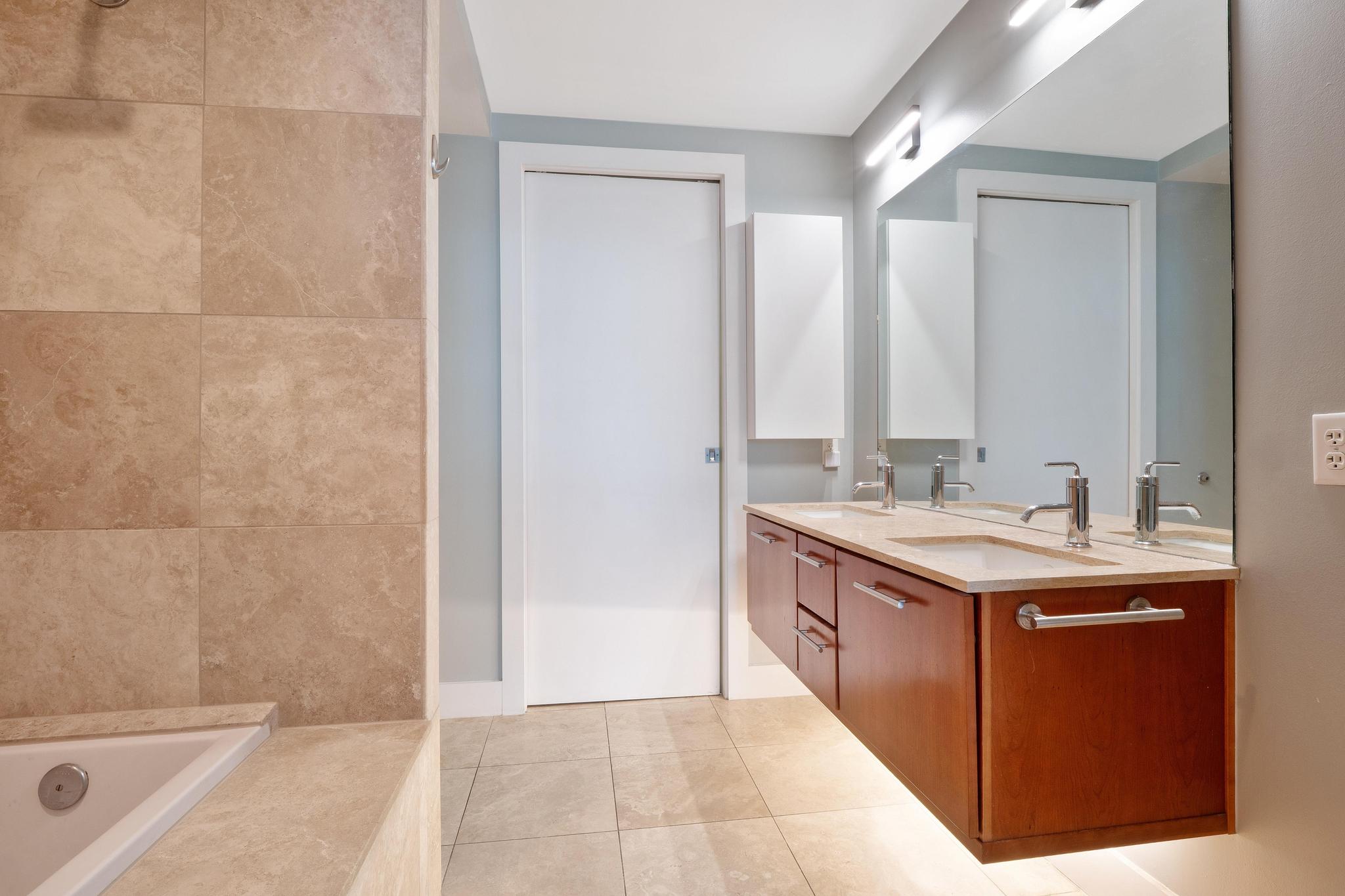 210 Lee Barton Drive, Unit 415 Austin, TX 78704 - Photo 8 of 22 Full bathroom with double vanity, a sink, a bath, and tile patterned flooring