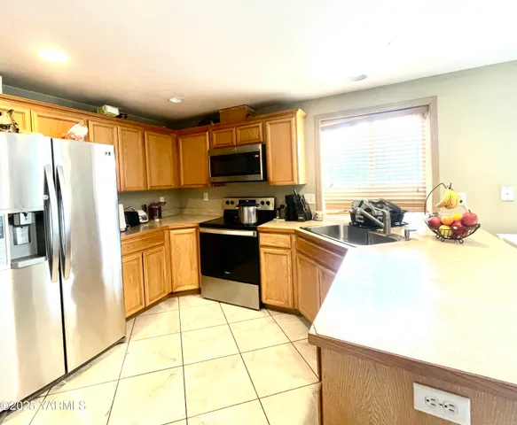 a kitchen with a sink a counter top space cabinets stainless steel appliances and a window