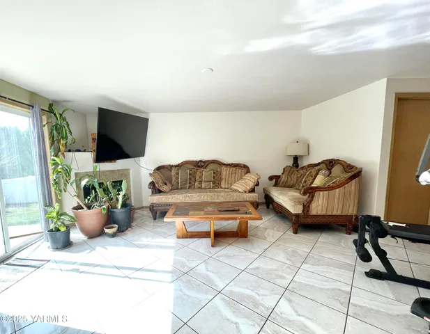 a living room with furniture gym equipment and a flat screen tv