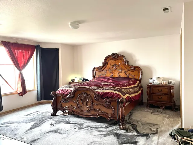 a bed sitting in a bedroom next to a window