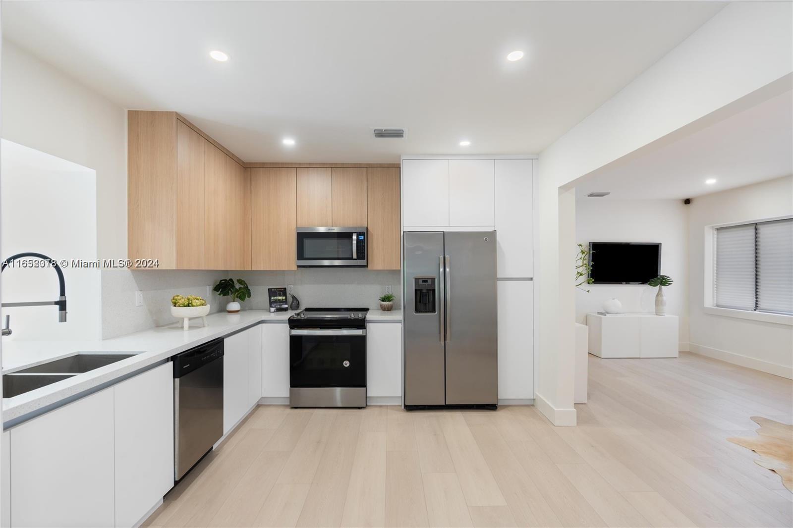 151 Northwest 146th Street Miami, FL 33168 - Photo 11 of 35 a kitchen with stainless steel appliances a refrigerator stove microwave and sink