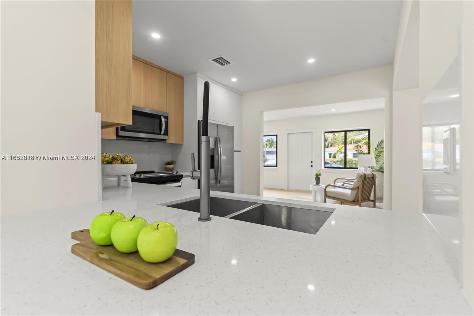 151 Northwest 146th Street Miami, FL 33168 - Photo 12 of 35 a kitchen with a sink a counter and chairs