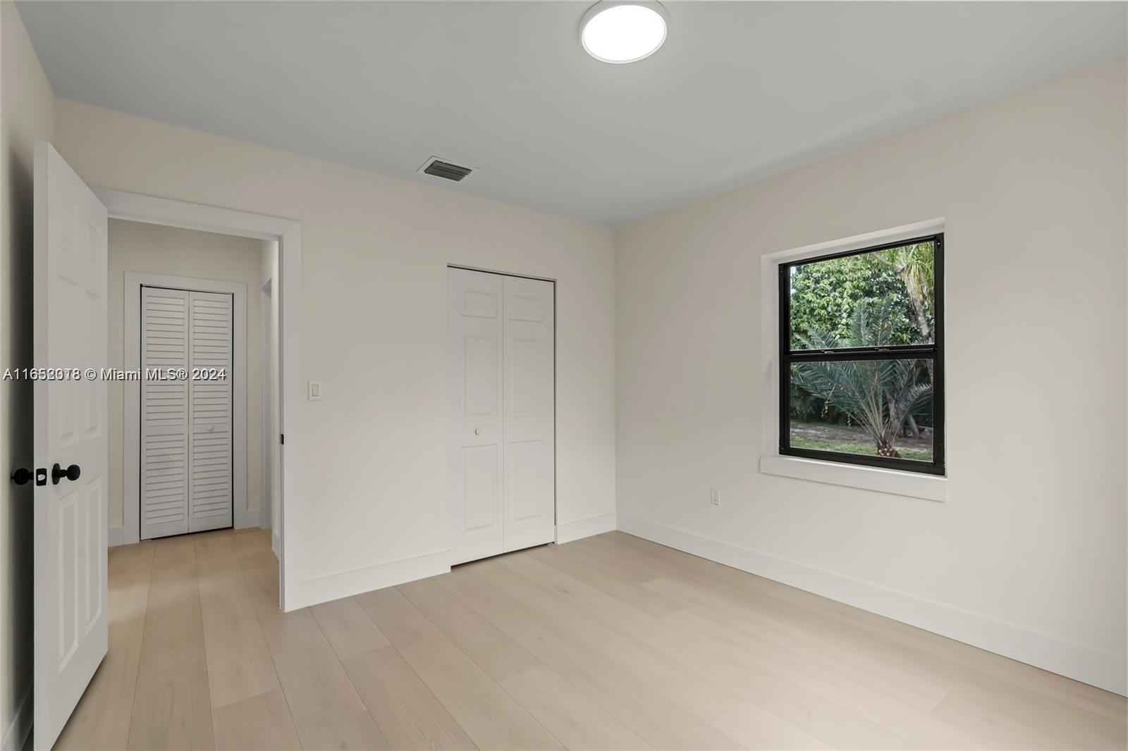 151 Northwest 146th Street Miami, FL 33168 - Photo 29 of 35 an empty room with windows and closet
