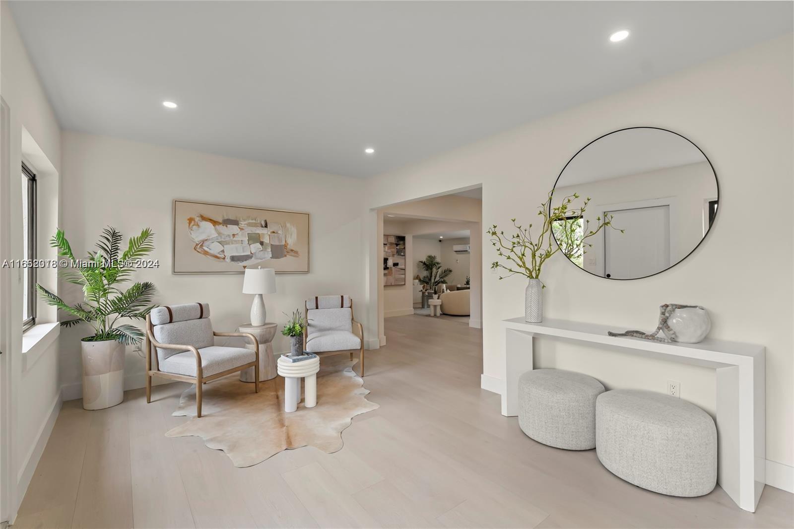 151 Northwest 146th Street Miami, FL 33168 - Photo 4 of 35 a living room with furniture a mirror and a chandelier