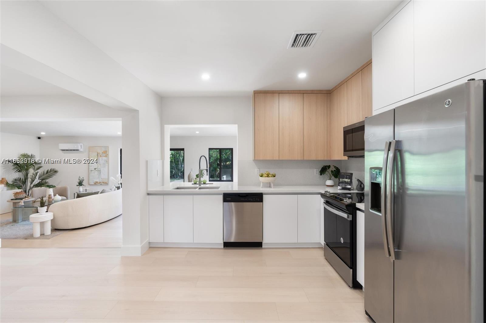 151 Northwest 146th Street Miami, FL 33168 - Photo 9 of 35 a kitchen with white cabinets and stainless steel appliances
