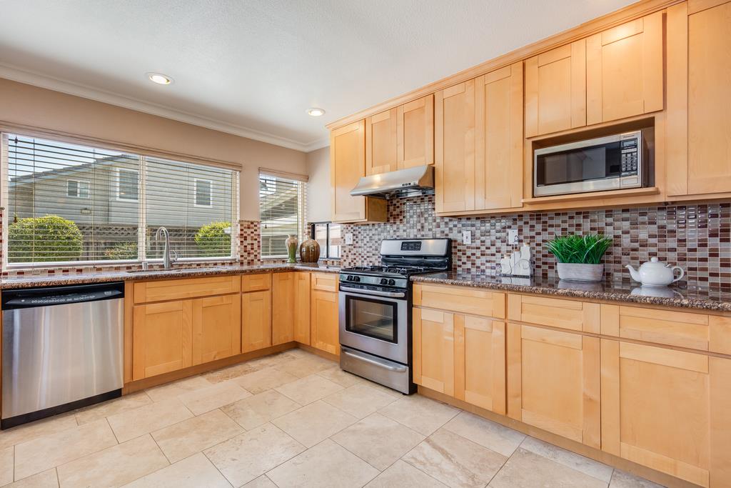 3129 Bilbo Drive San Jose, CA 95121 - Photo 9 of 34 a kitchen with granite countertop white cabinets white stainless steel appliances with a sink and dishwasher
