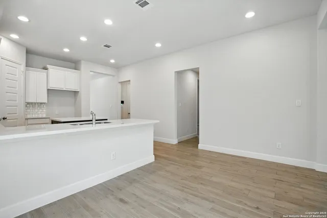 a large kitchen with stainless steel appliances a large counter top a sink and a refrigerator