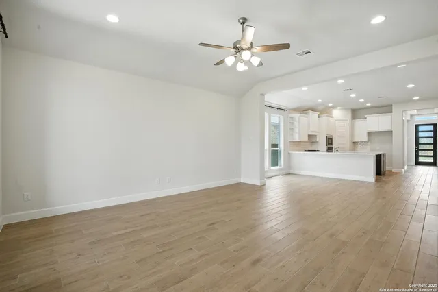 a view of a livingroom with a kitchen island a sink dishwasher with wooden floor