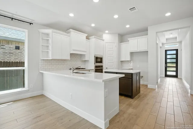a kitchen with stainless steel appliances kitchen island granite countertop a stove a sink and a refrigerator