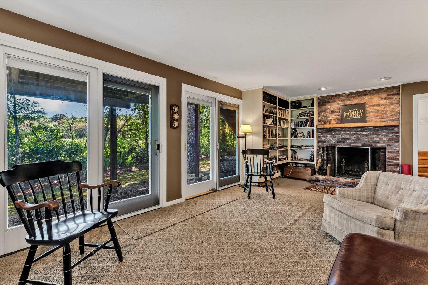 5 Tide Run Mashpee, MA 02649 - Photo 51 of 64 a living room with furniture a fireplace and a floor to ceiling window