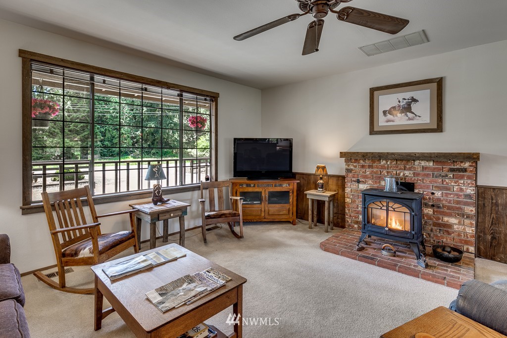 4903 169th Street Southeast Bothell, WA 98012 - Photo 11 of 32 a living room with furniture a flat screen tv and a fireplace