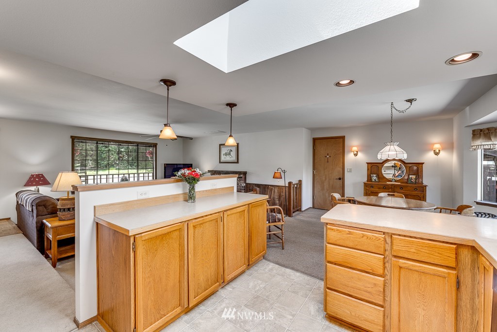 4903 169th Street Southeast Bothell, WA 98012 - Photo 15 of 32 a room with kitchen island a sink and a large mirror with wooden floor