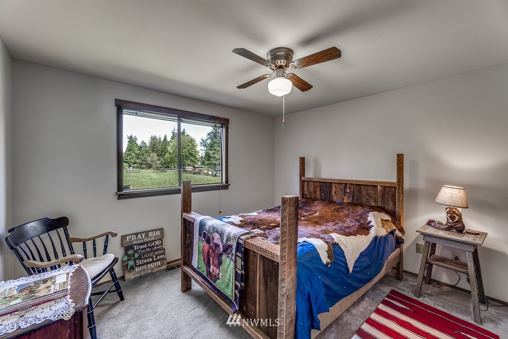 4903 169th Street Southeast Bothell, WA 98012 - Photo 17 of 32 a bedroom with a bed a chandelier and a window
