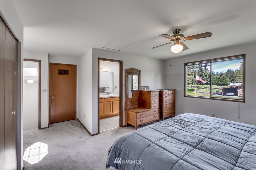 4903 169th Street Southeast Bothell, WA 98012 - Photo 22 of 32 a bedroom with a large bed and a chandelier