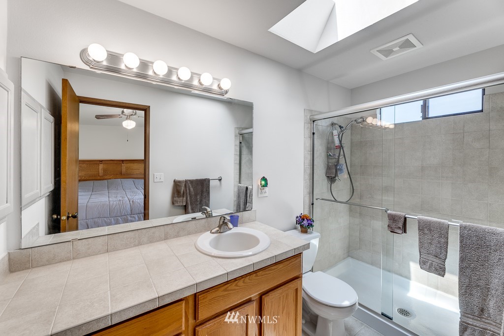 4903 169th Street Southeast Bothell, WA 98012 - Photo 23 of 32 a bathroom with a sink toilet a mirror and shower