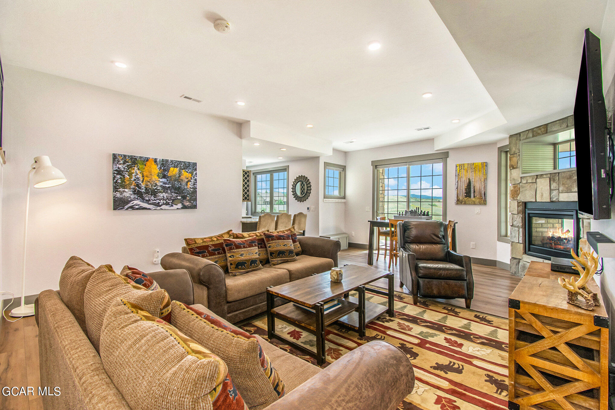 609 Lower Ranch View Drive Granby, CO 80446 - Photo 27 of 54 a living room with furniture two large window and a flat screen tv