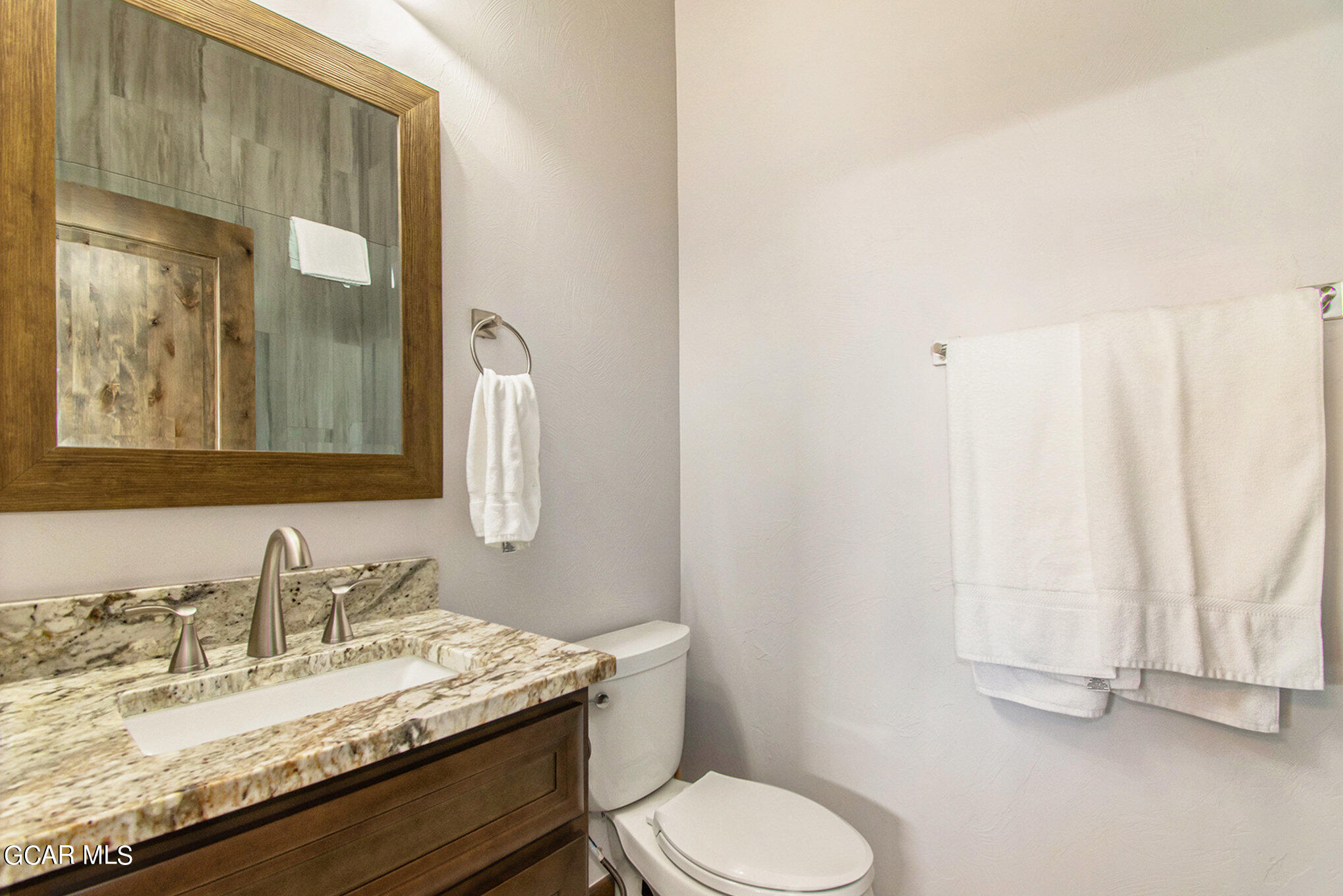 609 Lower Ranch View Drive Granby, CO 80446 - Photo 40 of 54 a bathroom with a granite countertop sink toilet and mirror