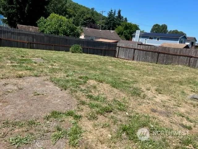 a view of backyard with wooden fence