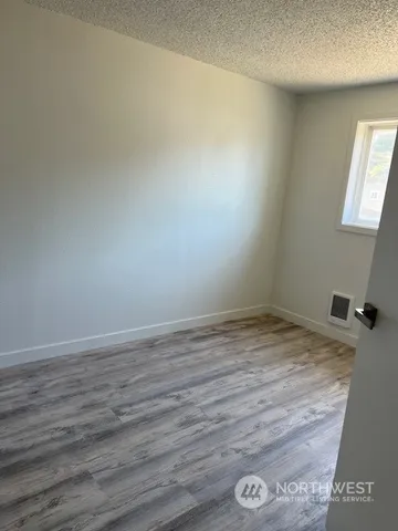 a view of empty room with wooden floor