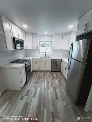 a kitchen with a sink a refrigerator a microwave and cabinets