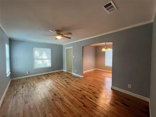 a view of empty room with wooden floor