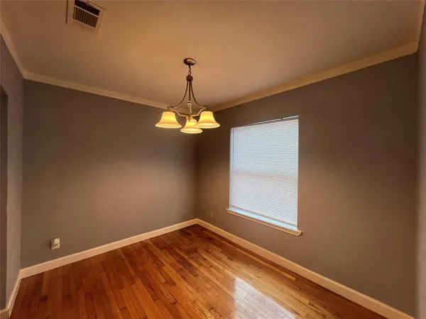 a view of a room with a ceiling fan and hardwood