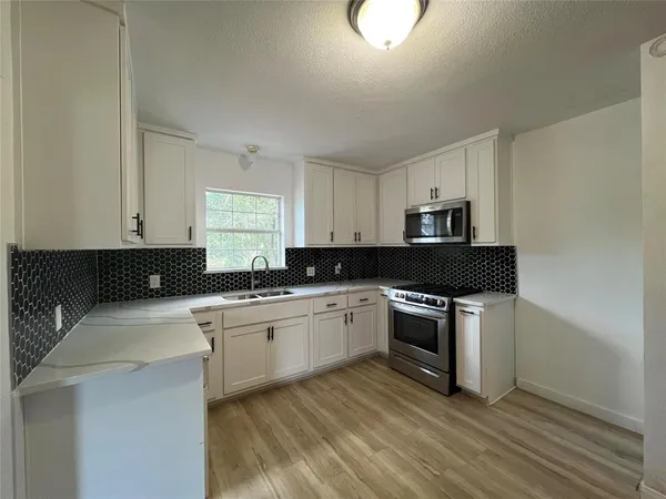 a kitchen with a stove top oven sink and cabinets