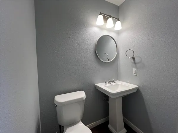 a bathroom with a toilet a sink and a mirror
