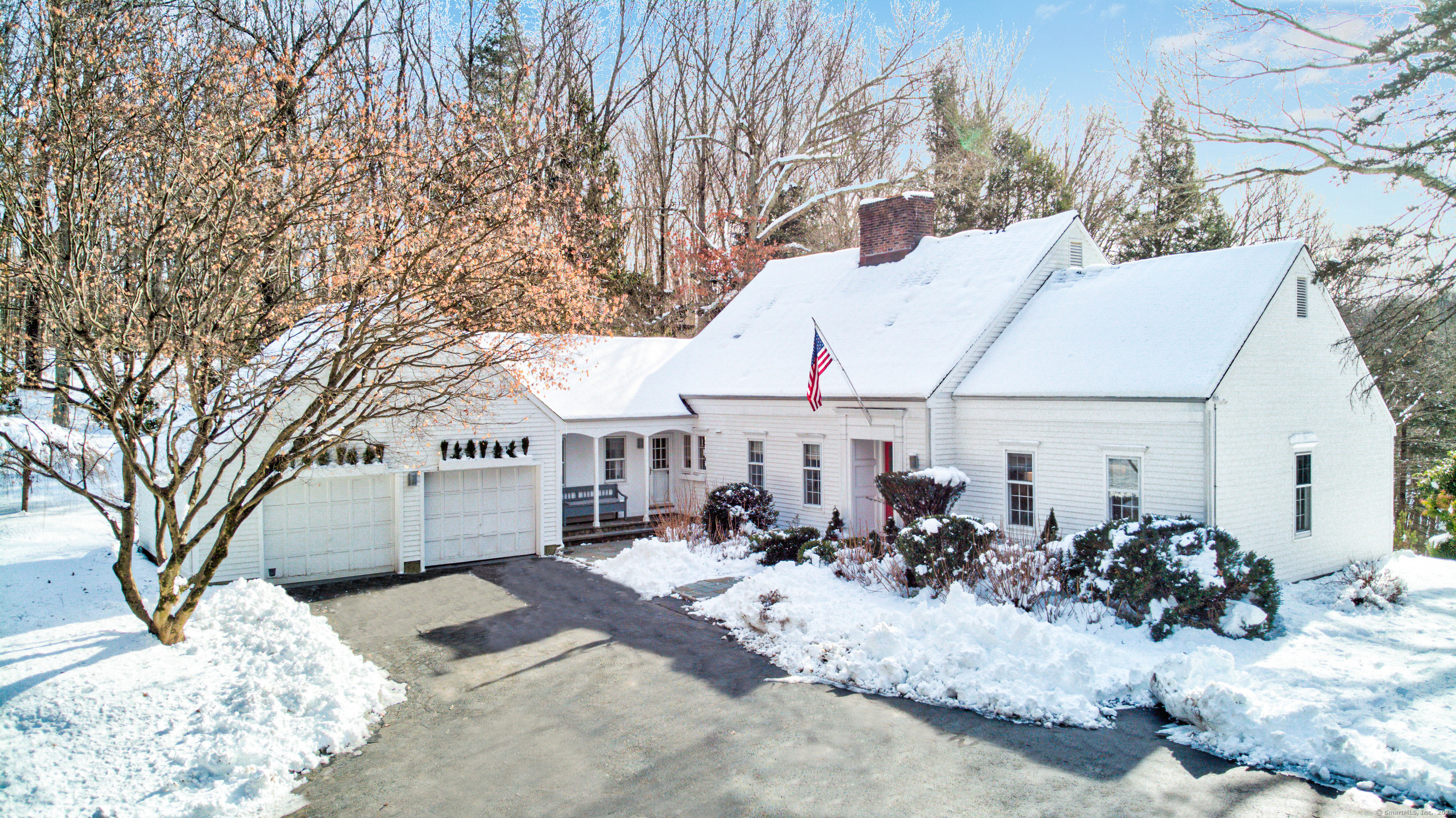 a view of a white house with a yard covered in snow