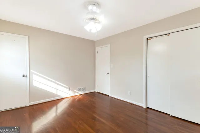 a view of empty room with wooden floor