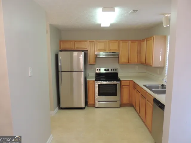 a kitchen with a refrigerator and a sink