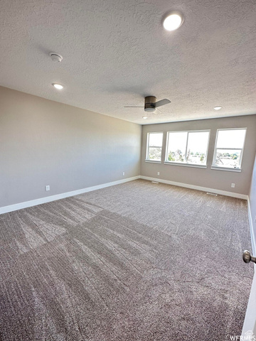 1171 West 2330 North Helper, UT 84526 - Photo 8 of 26 Spare room with carpet, a textured ceiling, a ceiling fan, and recessed lighting