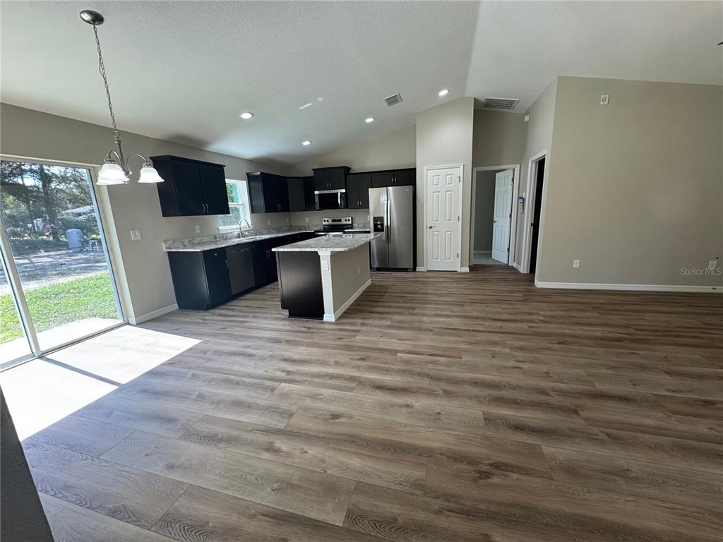 14876 Southwest 23rd Place Ocala, FL 34481 - Photo 7 of 26 a view of kitchen with stainless steel appliances kitchen island granite countertop a refrigerator a stove top oven and a sink with granite countertops