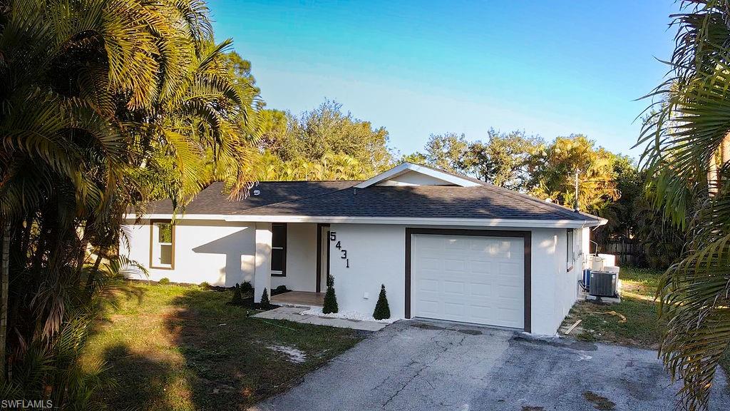5431 23rd Avenue Southwest Naples, FL 34116 - Photo 2 of 40 a front view of a house with garden