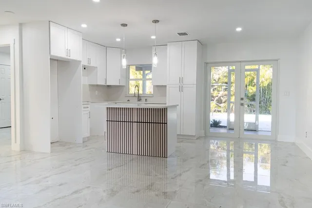 a kitchen with kitchen island stainless steel appliances a refrigerator a sink and a stove top oven