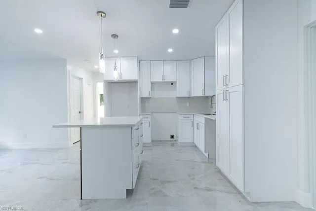 a open kitchen with white cabinets and stainless steel appliances