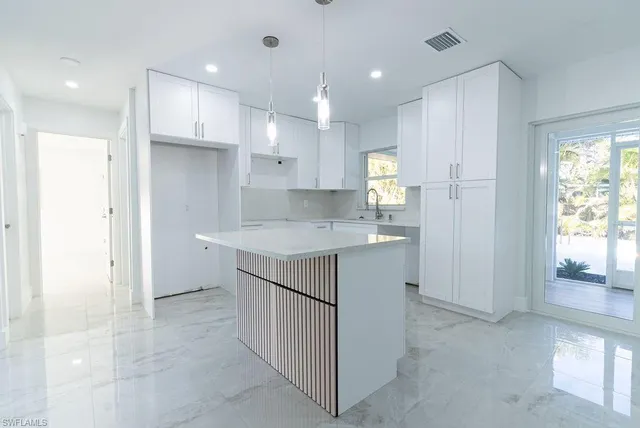 a kitchen with kitchen island cabinets and refrigerator