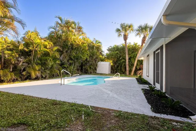 a white house with a yard and a trees